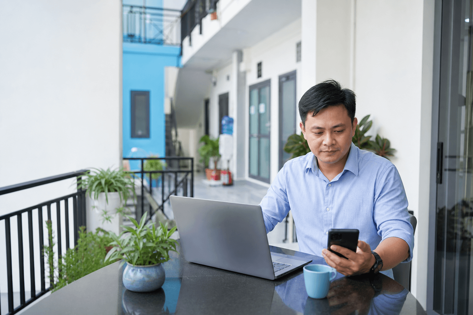 Chủ nhà trọ Việt Nam kiểm tra hóa đơn và công nợ trên điện thoại trong khu căn hộ mini sáng sạch